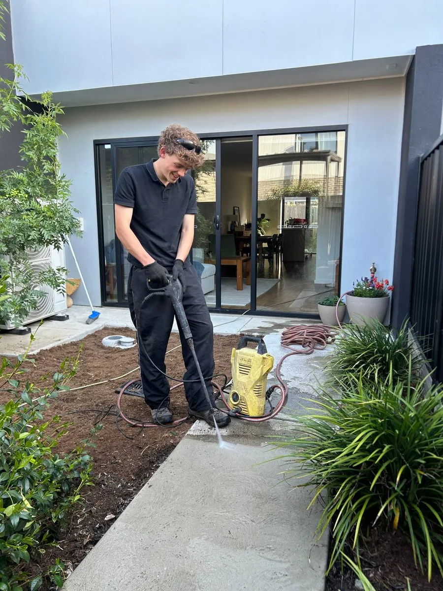 Crew member Julian pressure washing